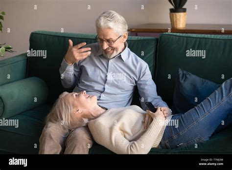 Smiling Mature Wife Lying On Husband Knees Relaxing At Home Stock Photo Alamy