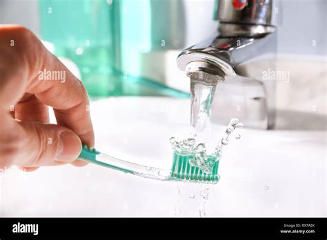 Daily Cleaning Of The Toothbrush After Use In The Bathroom Sink