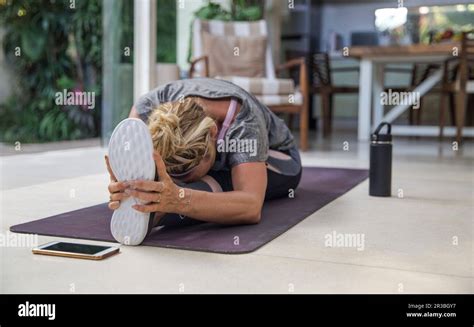 Woman Practicing Janu Sirsasana On Exercise Mat At Home Stock Photo Alamy