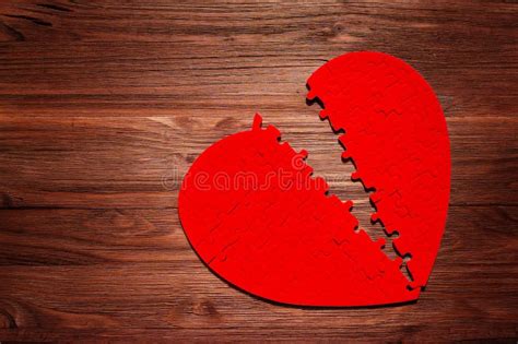 Red Heart Puzzle Split In Half On A Wooden Table Stock Image Image Of