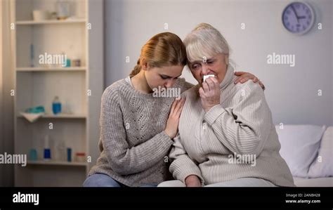 Granddaughter Hugging And Supporting Crying Grandmother Incurable