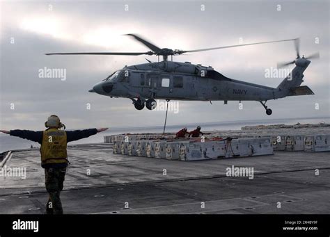 US Navy Aviation Boatswain S Mate 3rd Class Directs An MH 60S Seahawk