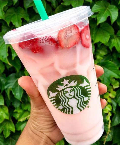 Someone Holding Up A Starbucks Drink With Strawberries On It In Front