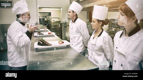 Chefs Presenting Their Dessert Plates To Head Chef In Commericial