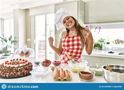 Beautiful Young Brunette Pastry Chef Woman Cooking Pastries At The Kitchen Very Happy And