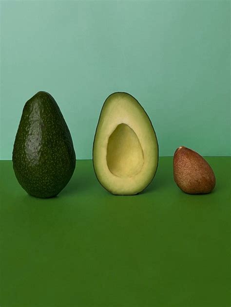 Three Avocados Are Sitting On A Green Surface