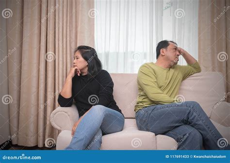 Husband And Wife Sitting On Different Sides Of Sofa Quarrel Con Stock