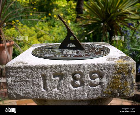 Old sundial on a plinth in a garden setting Stratford UK Stock Photo ...