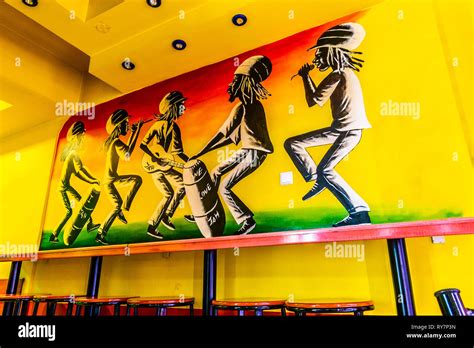 Depicted Five Dancing Reggae Jamaicans With Music Instruments On A Wall