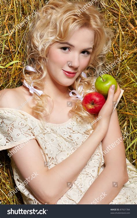 Portrait Of Beautiful Blonde Country Girl Sittitng On Yellow Hay With