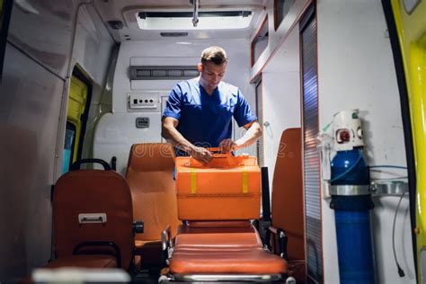 Paramedic Presses An Oxygen Mask To A Woman`s Face Who Is Lying On A