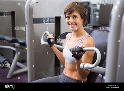 Healthy Happy Brunette Using Weights Machine For Arms Stock Photo Alamy