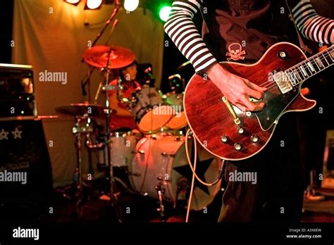 Close Up Of Rock And Roll Guitarist On Stage With Drummer In The