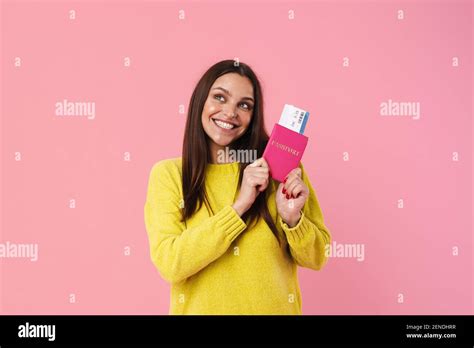 Happy Brunette Girl Smiling While Posing With Passport And Tickets Isolated Over Pink Background