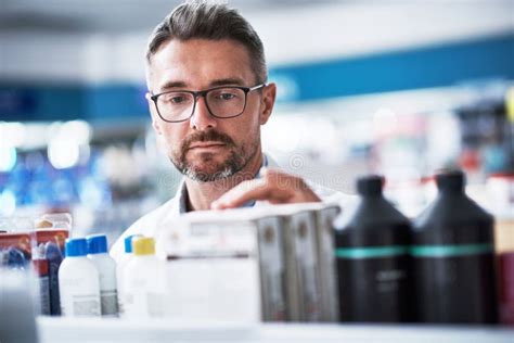 Organizing All His Stock A Mature Pharmacist Checking Products In A