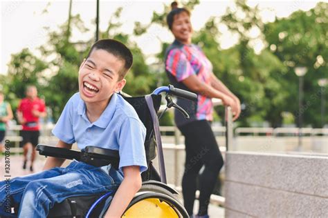 Disabled Child On Wheelchair Is Play And Learn In The Outdoor Park Like