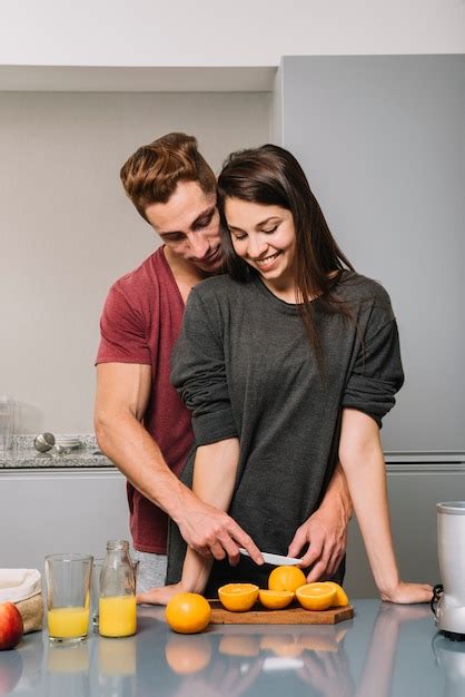 Homme Embrassant Une Femme Par Derrière Et Coupe Orange Photo Gratuite