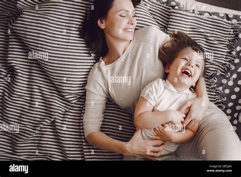 Beautiful Mother With 3 Year Old Daughter Hug And Laugh While Lying On