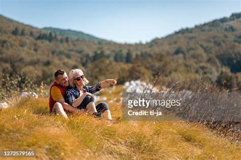 Couples Adultes Sasseyant Dans Lherbe Dans La Gamme De Montagne Photo