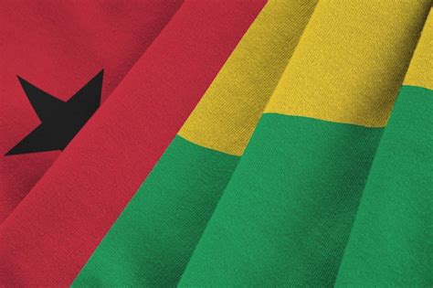 Premium Photo | Guinea bissau flag with big folds waving close up under the studio light indoors ...