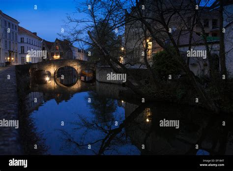 Augustijnenbrug Bridge And Canal Illuminated At Night In Bruges