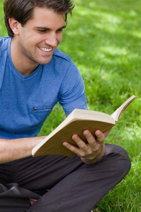 Giovane Uomo Sorridente Che Legge Un Libro Mentre Collocando Sullerba