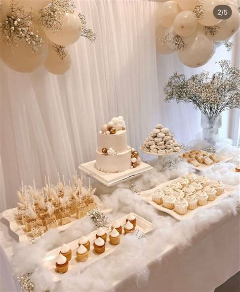 A Table Topped With Cakes And Cupcakes Next To Balloons In The Shape Of