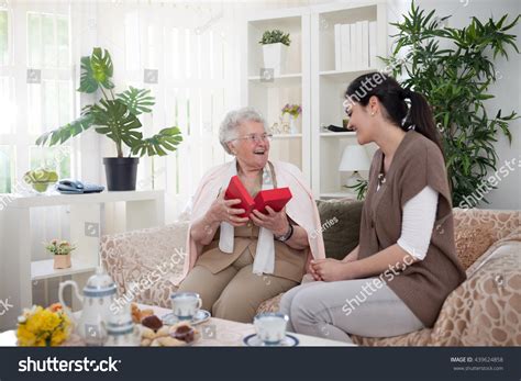 Surprised And Happy Grandma Opening A T From Her Granddaughter Stock