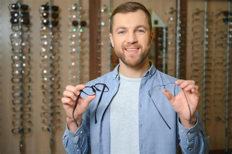 El Hombre Est Eligiendo Gafas En La Tienda De Ptica Foto Premium