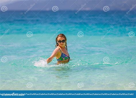 Young Beautiful Girl Splashes In The Blue Water Of The Ocean Stock