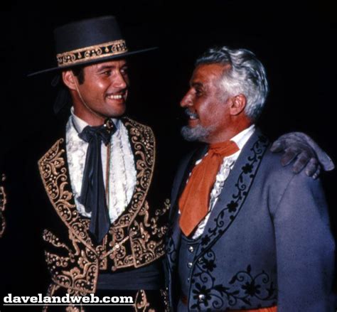 two men in suits and hats standing next to each other