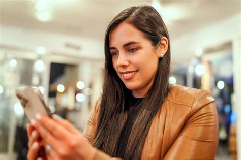 Mujer Latina Joven Que Usa Un Dispositivo M Vil Y Sonr E En El Interior De Un Restaurante O Pub