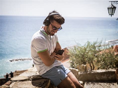 Handsome Man Listening To Music On Headphones Outdoor Stock Image Image Of Shorts Italy