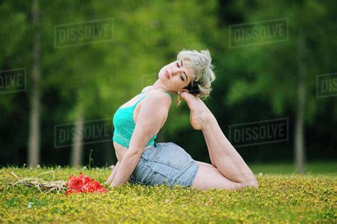 Caucasian Woman Laying In Field Arching Back Stock Photo Dissolve