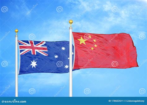 Australia And China Two Flags On Flagpoles And Blue Cloudy Sky Stock