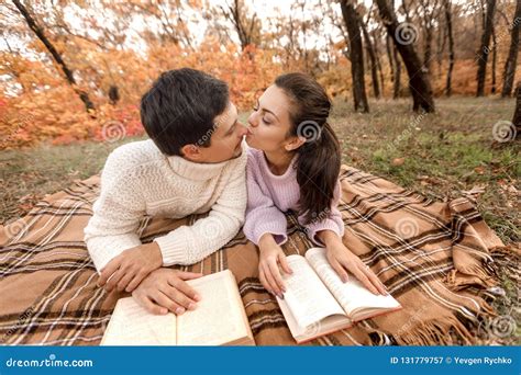 Couple In Love Sitting In Autumn Park And Reading Book Stock Image