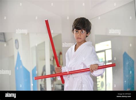 Martial Arts Boy Holding Two Red Sticks Called Ka Li Fighting Sticks