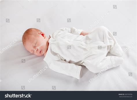 Newborn Baby Peacefully Sleeping On A White Background Stock Photo