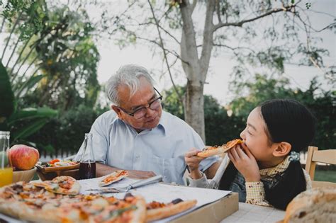 O Avo Comendo A Neta - Avô e neta comendo pizza no jardim em casa. estilo de vida de idade de ...