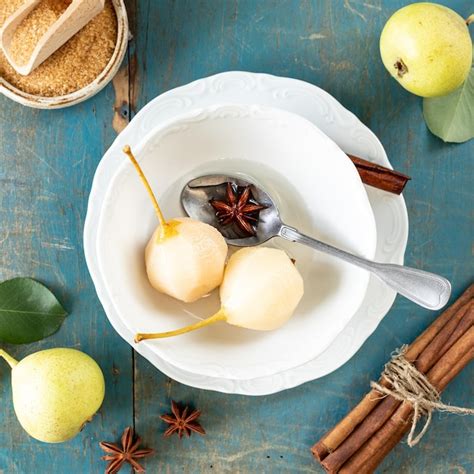 Plato Blanco Con Deliciosas Peras En Vino Sobre Una Mesa De Madera