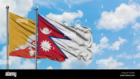 Bhutan and Nepal flag waving in the wind against white cloudy blue sky ...