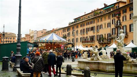 Tourists Walking In Piazza Navona With The Traditional Christmas Market