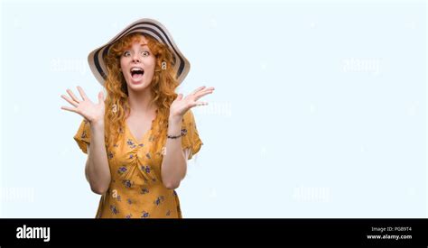 Young Redhead Woman Wearing Summer Hat And Dress Very Happy And Excited