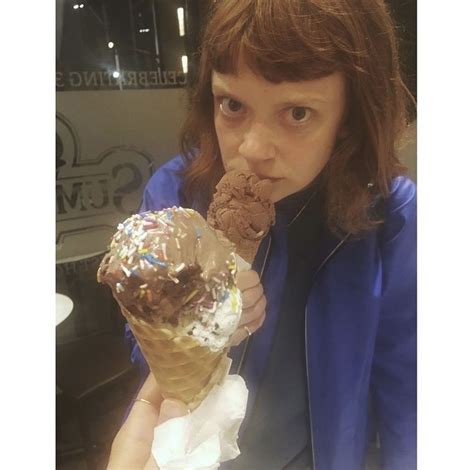 A Woman Eating An Ice Cream Cone Filled With Chocolate And Sprinkles