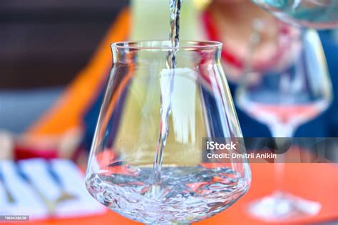 Close Up Pouring Purified Fresh Drink Water From The Bottle On A Table