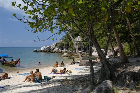 Colorful Longtail Boats And Tourists Sunbathing On White Sands Of A