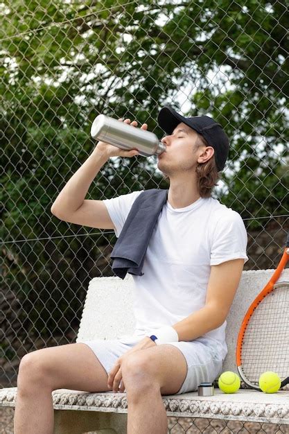 Jugador De Tenis Bebiendo Agua Sentado En Un Banco Descansando Despu S