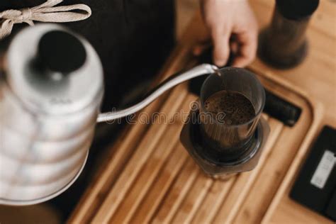 Barista Profesional En El Delantal Elegante Negro Que Vierte La Agua