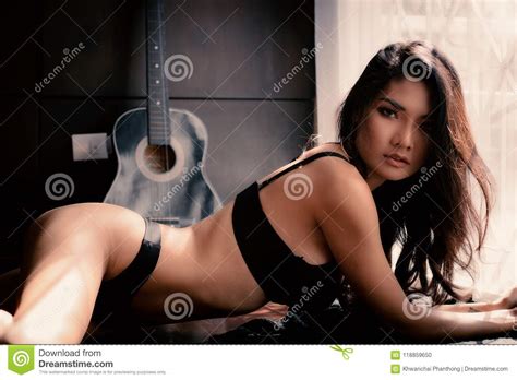 Women In Sensual Black Lingerie Laying On Dark Wood Floor In Vintagle