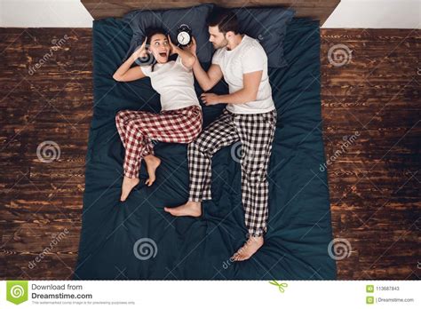 Top View Adult Handsome Man With Alarm Clock Woke Up Young Woman Lying